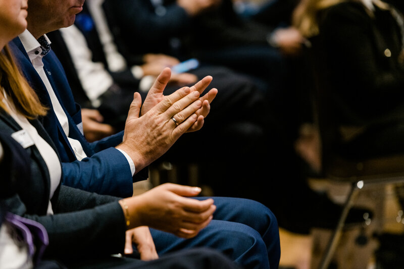 Symp_Applaus | © FH Kufstein Tirol Eine Person die im Publikum sitzt klatscht mit den Händen. | © FH Kufstein Tirol