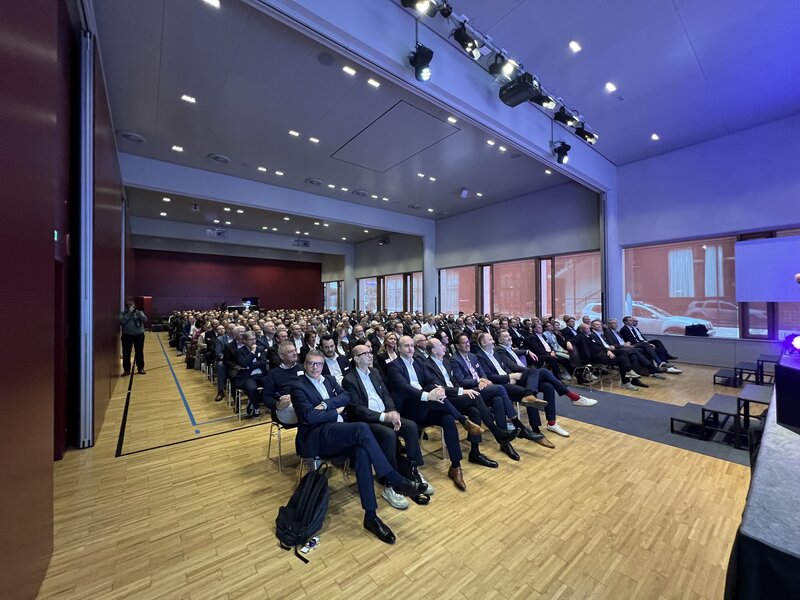 2024_Plenum | © FH Kufstein Tirol Großer bestuhlter Veranstaltungssaal mit vielen Teilnehmer:innen, am Bildrand ist der Rand einer Bühne zu sehen, das Publikum verfolgt aufmerksam die Veranstaltung | © FH Kufstein Tirol